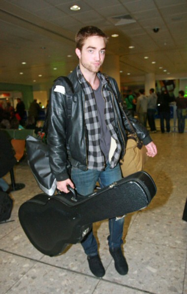 Robert Pattinson all'aeroporto con la sua chitarra