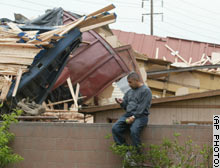 Un residente contempla sconsolato i resti della propria casa distrutta