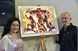 l'autore e l'artista Pietra Barrasso posano accanto al dipinto la fontana delle tartarughe
