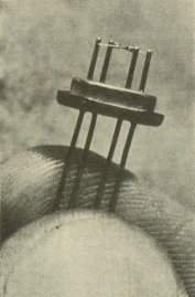Transistore a quattro fili uscenti.  un tetrodo adatto per frequenze molto elevate, in grado di amplificare i segnali televisivi e radar.  tenuto fra pollice e indice (Bell Telephone Laboratories).